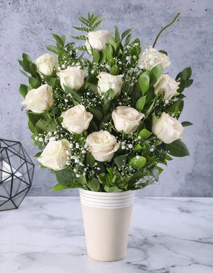 Arrangement of cream roses in a white vase